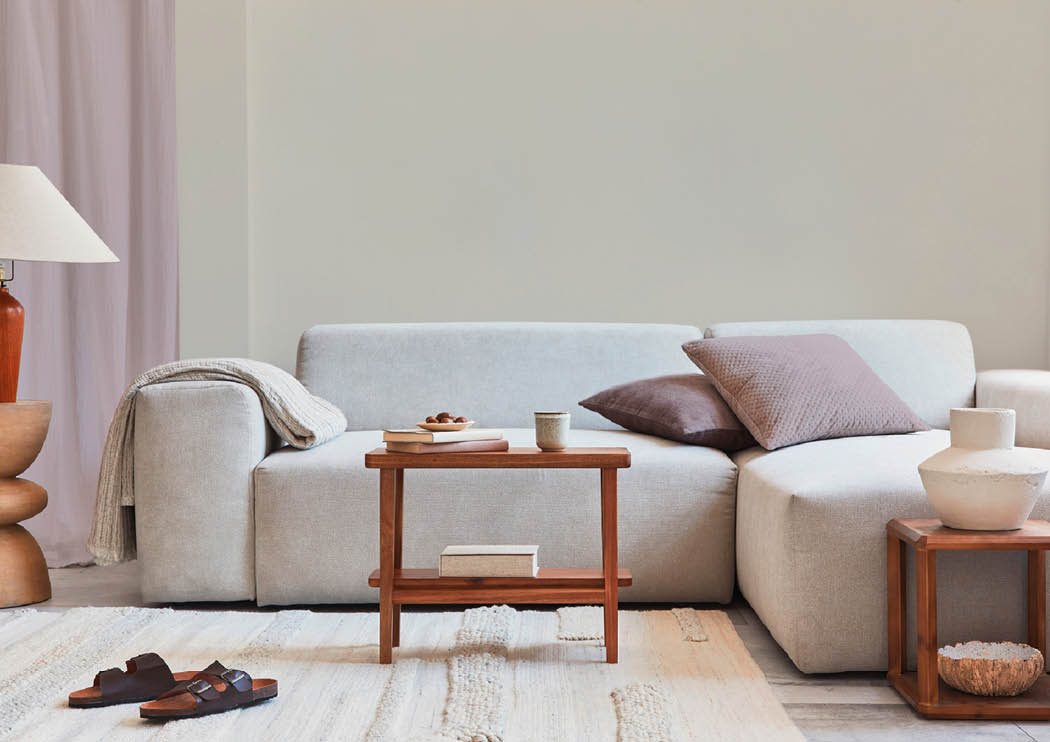 Creative composition of stylish and cozy living room interior with mock up frame, grey corner sofa, window, coffee tabels and personal accessories. Beige neutral colors. Template.