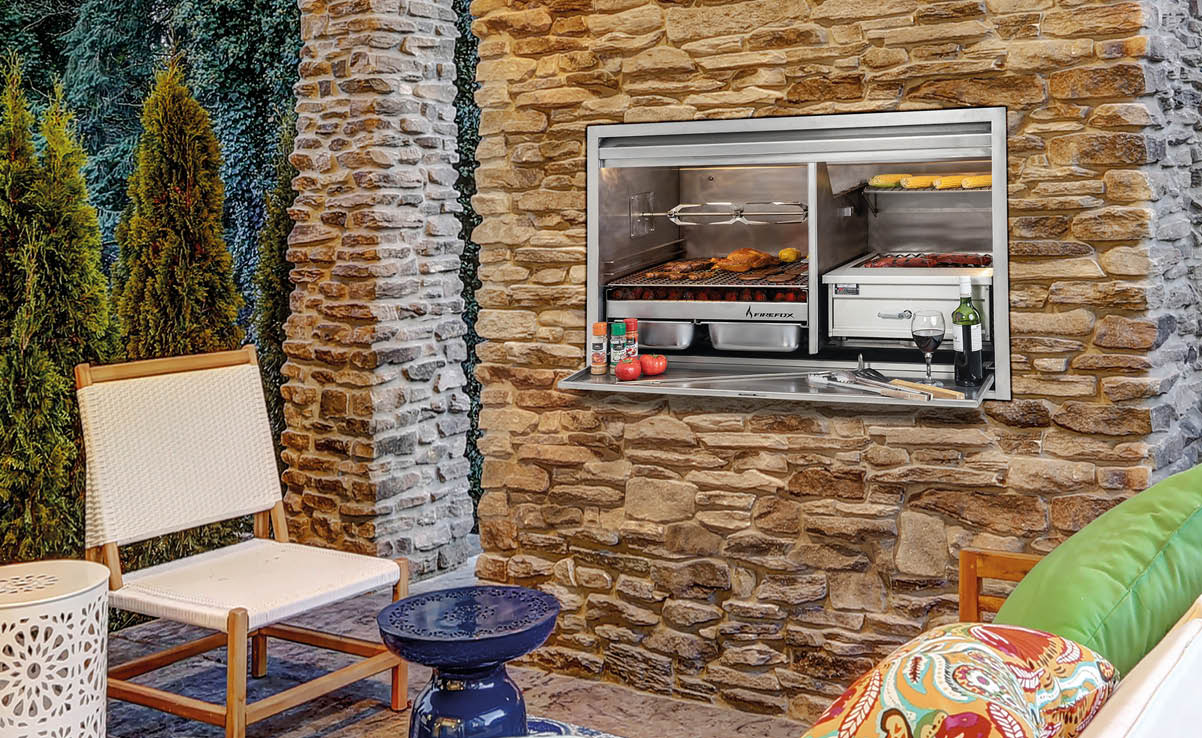 Chic covered back patio with built in gas fireplace, stone pillars, plank vaulted ceiling over cozy teak wood sofa set topped with white cushions and green pillows. Northwest, USA