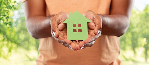 eco living, environment and sustainability concept - close up of young african american man holding green house icon over natural background; Shutterstock ID 1964147500; PN: Aerolite/ Isover